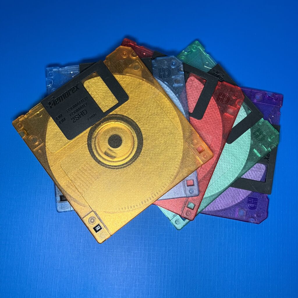 Colorful translucent 3.5-inch floppy disks stacked on a blue background
